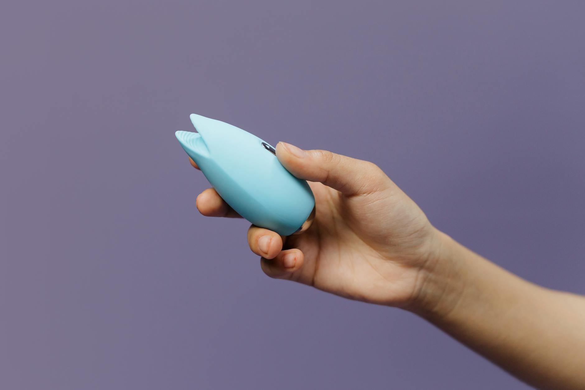 Paar hält einen blauen Vibrator in der Hand und symbolisiert gemeinsame moderne Intimität