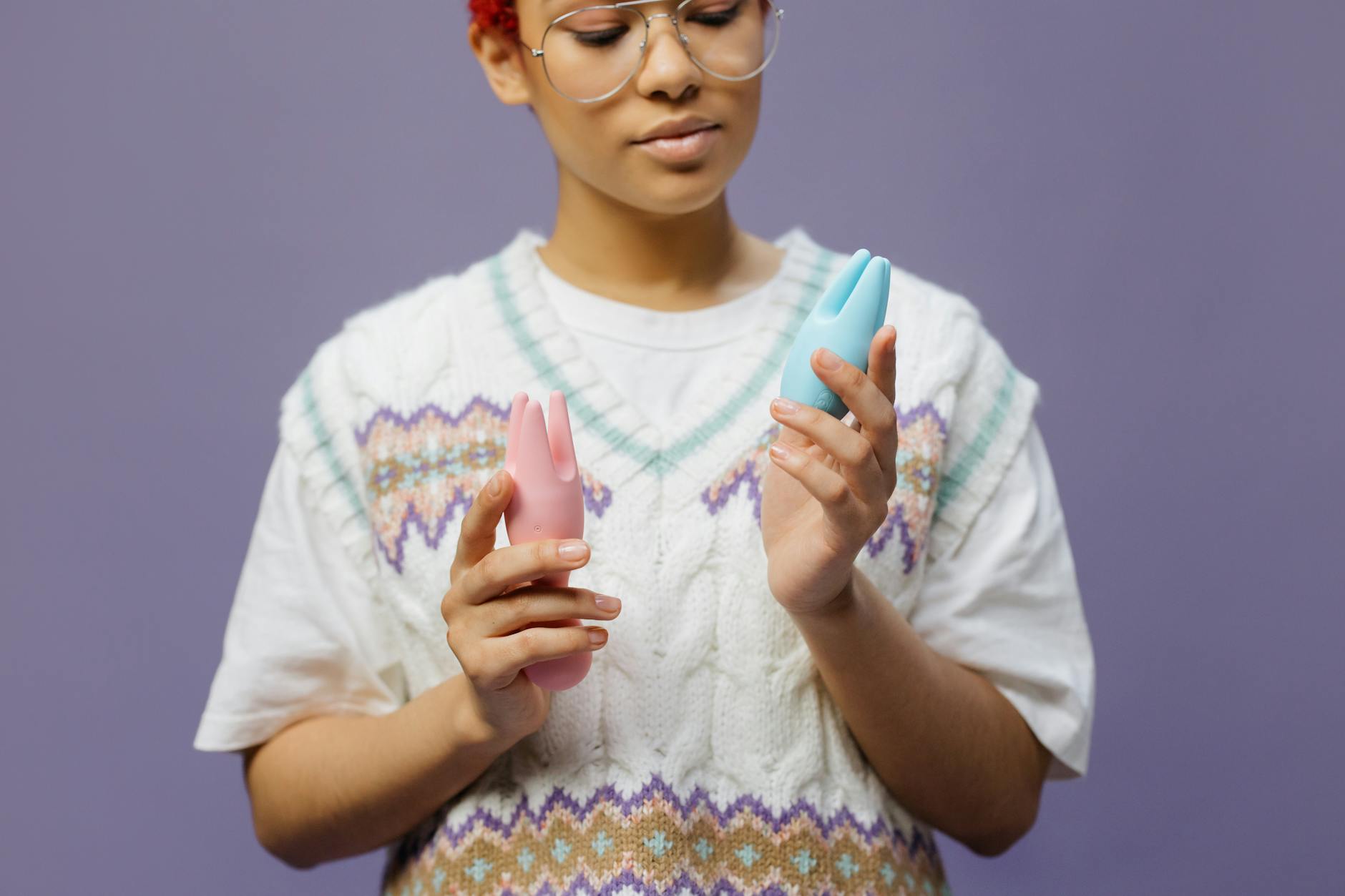 Frau mit Brille hält einen blauen Lemon-Vibrator in nachdenklicher Pose
